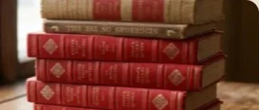A stack of red leather-bound books by a window